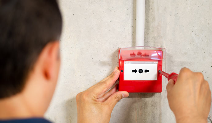 Professional worker installing fire alarm system