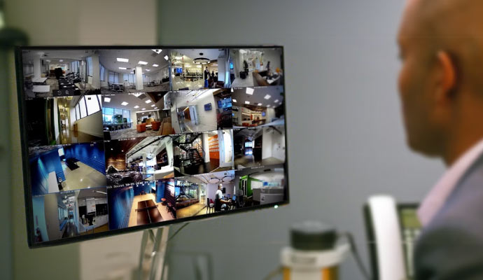 A man checking CCTV feeds in the computer display