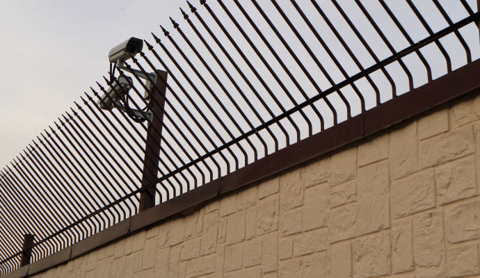 Security camera installed in the fence wall