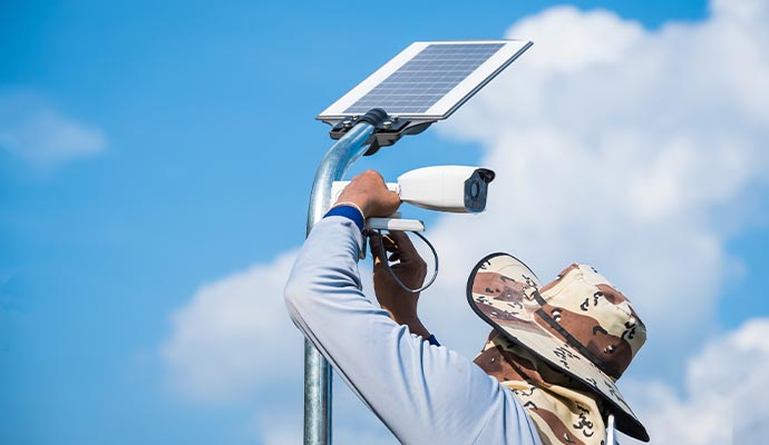 a professional installing a solar powered security camera