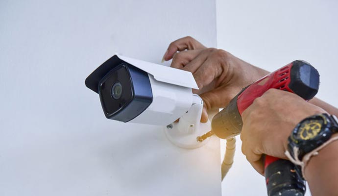 a professional installing a wireless outdoor camera